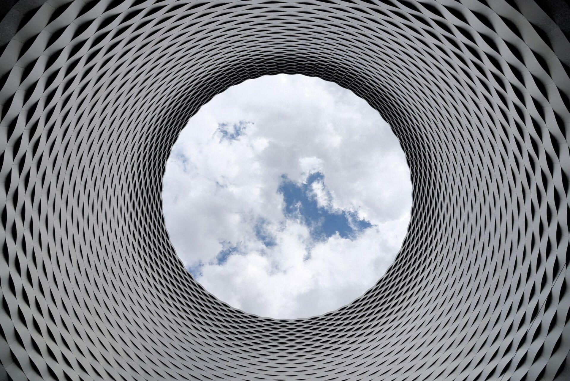 View through a geometric metal funnel of the cloudy sky