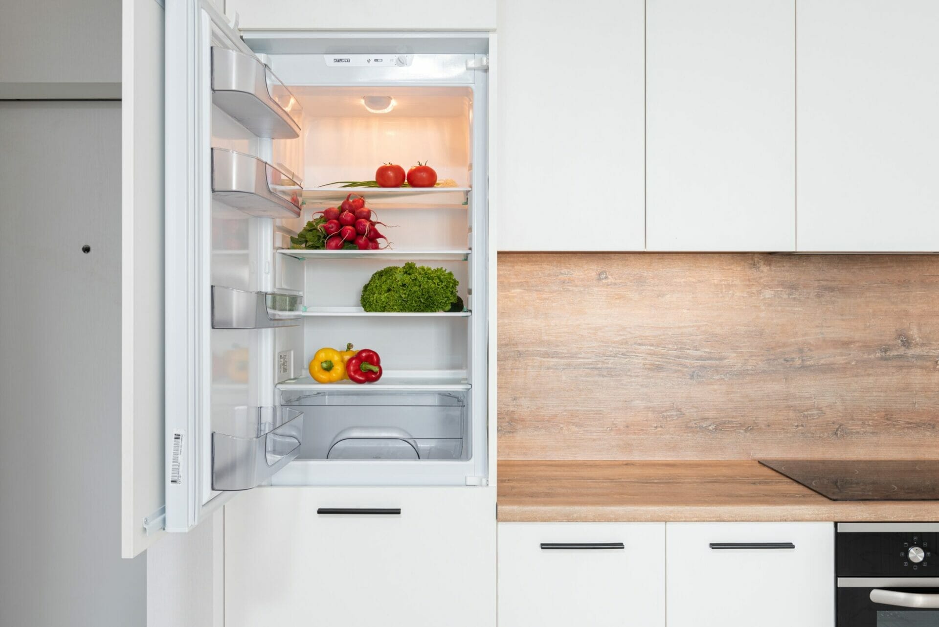 fruit veg storage Kitchen view with fridge door open, various fresh fruit & veg inside fridge