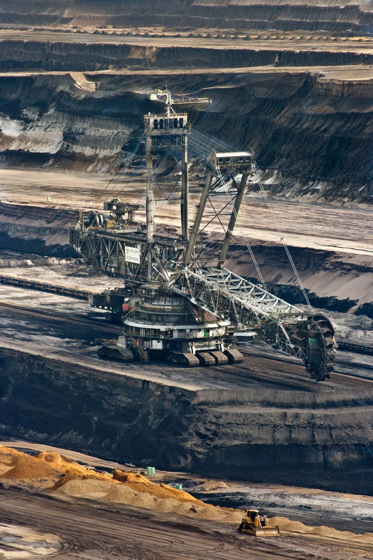 Steel mining crane in dark soil open quarry