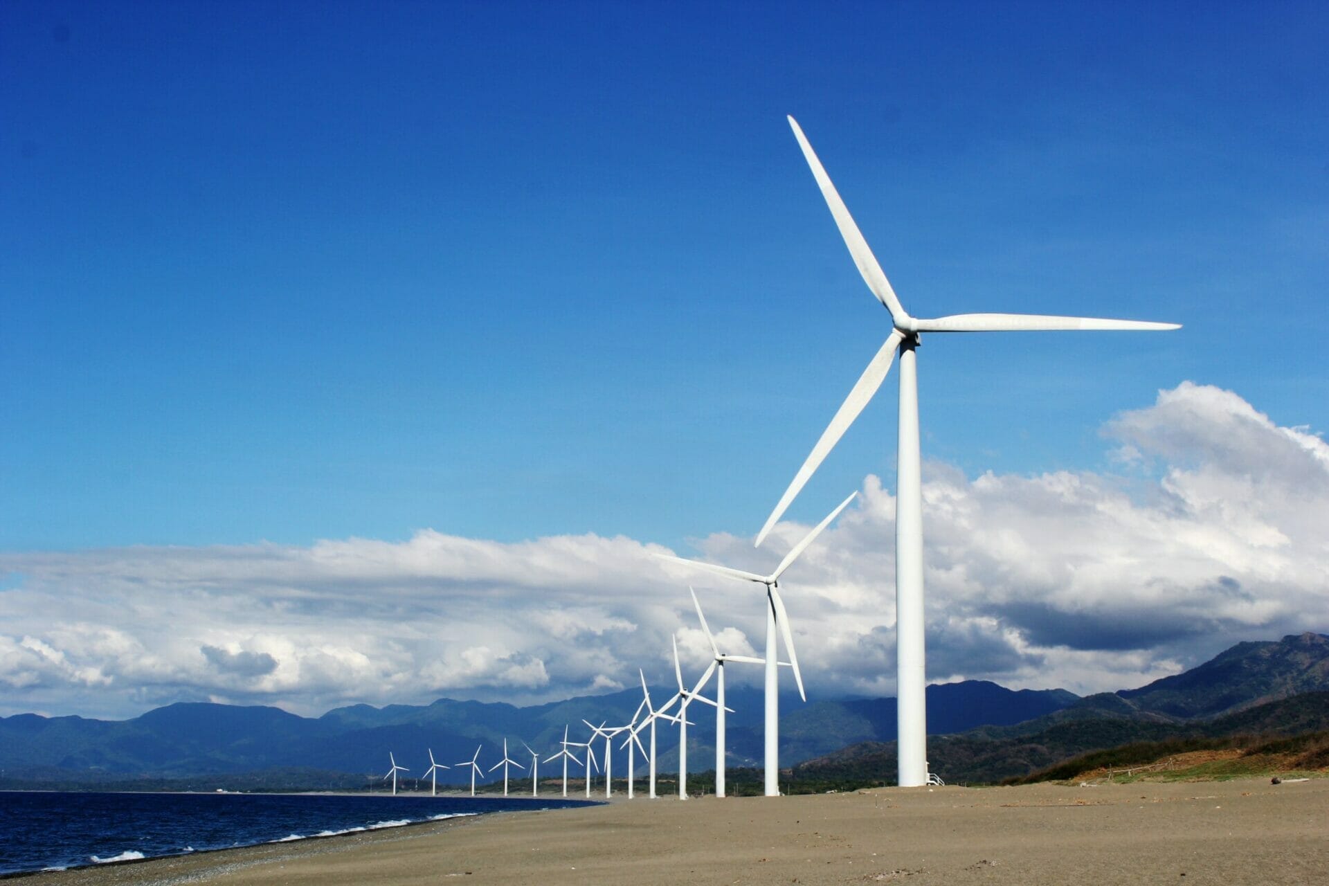 Landscape with long row of wind turbines stretching towards the horizon